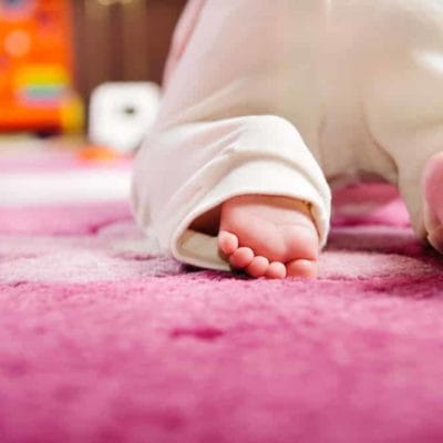 bébé sur un tapis enfant rose