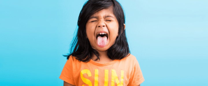 enfant qui tire la langue pour illustrer un article sur les enfants hyperactifs