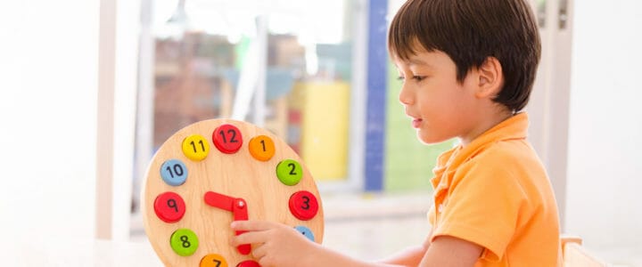 Little boy learning time with clock toy of montessori educationa