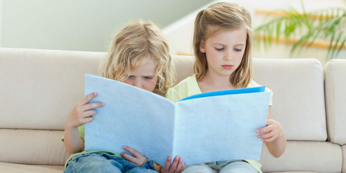 un-frere-et-sa-soeur-lisent-un-livre-sur-la-separation-des-parents-dans-le-salon